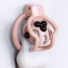 Pink spider-frame chastity cage showing removable silicone stud placement